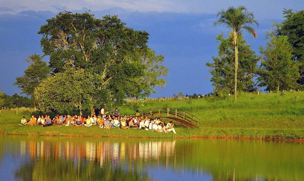 Grupo reunido à beira do lago no parque do Instituto Visão Futuro, em Porangaba