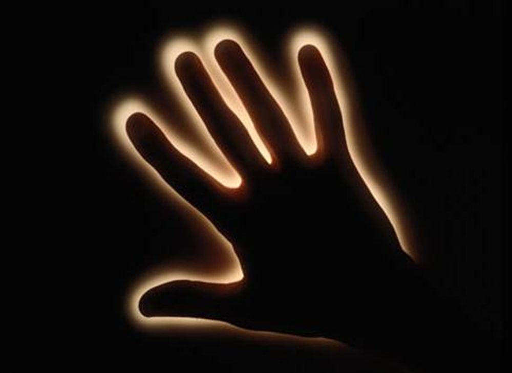 Mão humana emitindo luz visível nas bordas